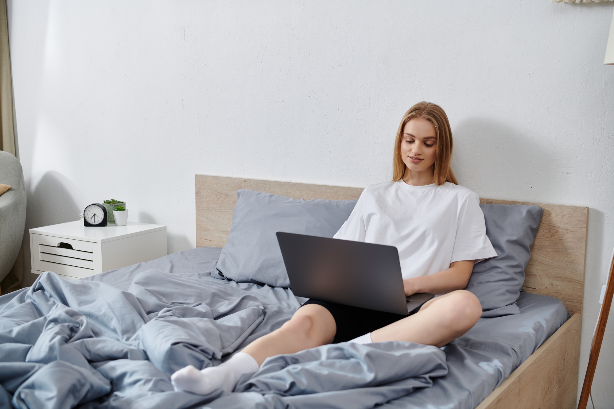 Young Woman Relaxing on Bed With Laptop